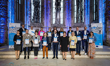 [Translate to English:] Gruppenbild mit den Siegelträgern und ihrer Urkunde gemeinsam mit der Ministerin Petra Grimm-Benne