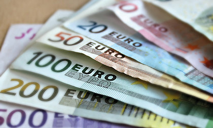 Mehrere Euroscheine liegen ausgefächert auf einem Tisch
