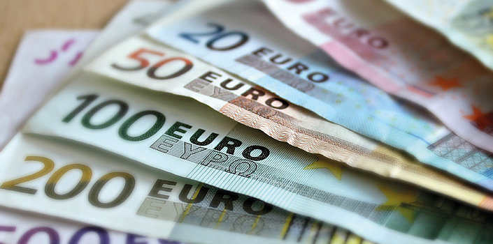 Mehrere Euroscheine liegen ausgefächert auf einem Tisch